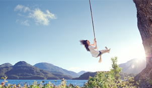 Woman on a swing by a cliff