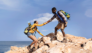 Woman and man climbing a rock